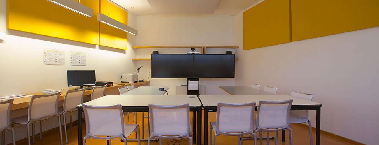 Sala conferenza e alle pareti pannelli tessili fonoassorbenti di colore giallo