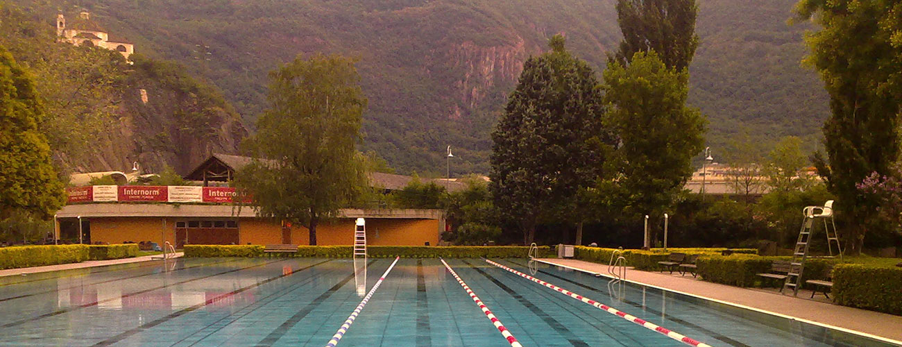 Piscina esterna a più corsie circondata da alberi e montagne